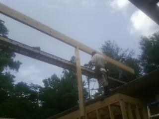 Carpenter setting a ridge beam over a new addition frame — Ice Dam Removal by Roofing Brothers in Sevierville