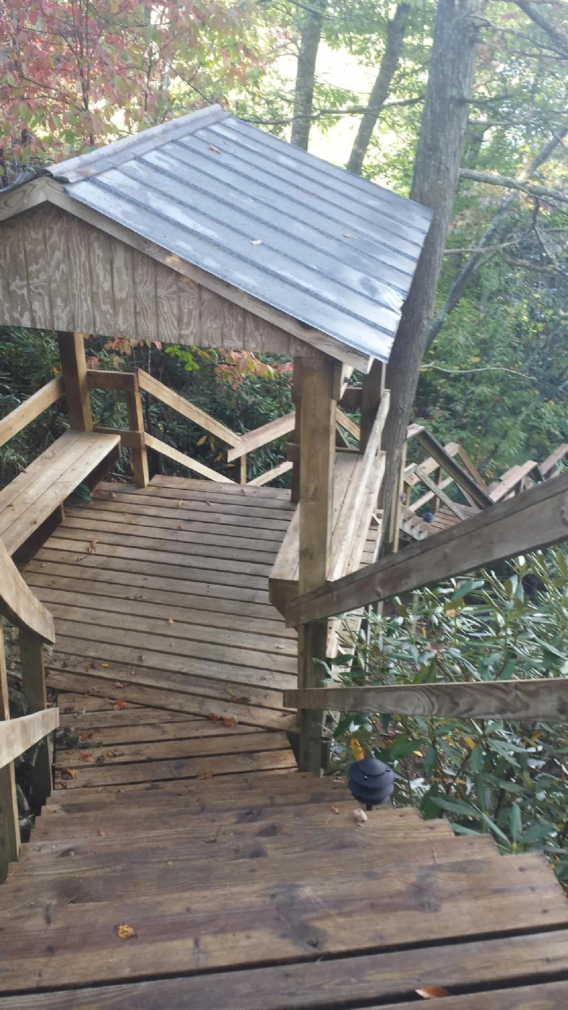 Metal roofed shelter over wooden steps on a wooded walkway — Skylight Repair & Installation work by our crew in Sevierville