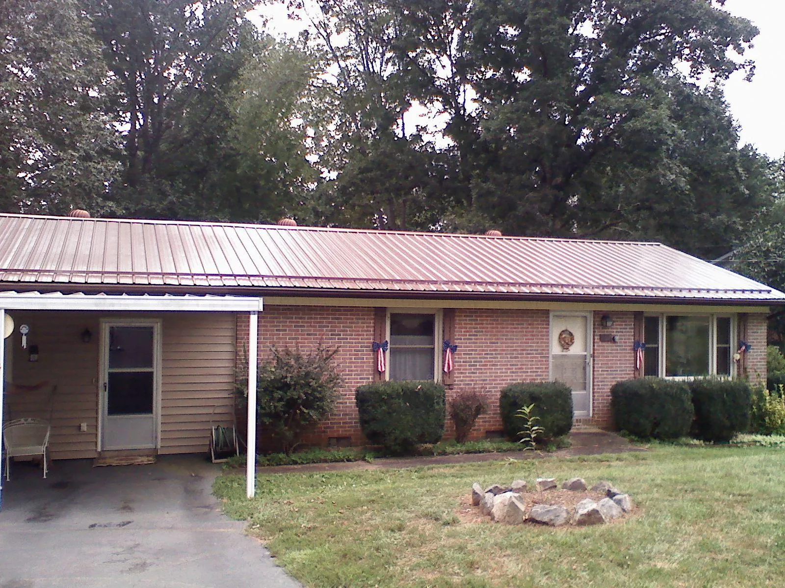 Bronze metal roof and carport on a brick ranch home — Roof Repair work by our crew in Sevierville