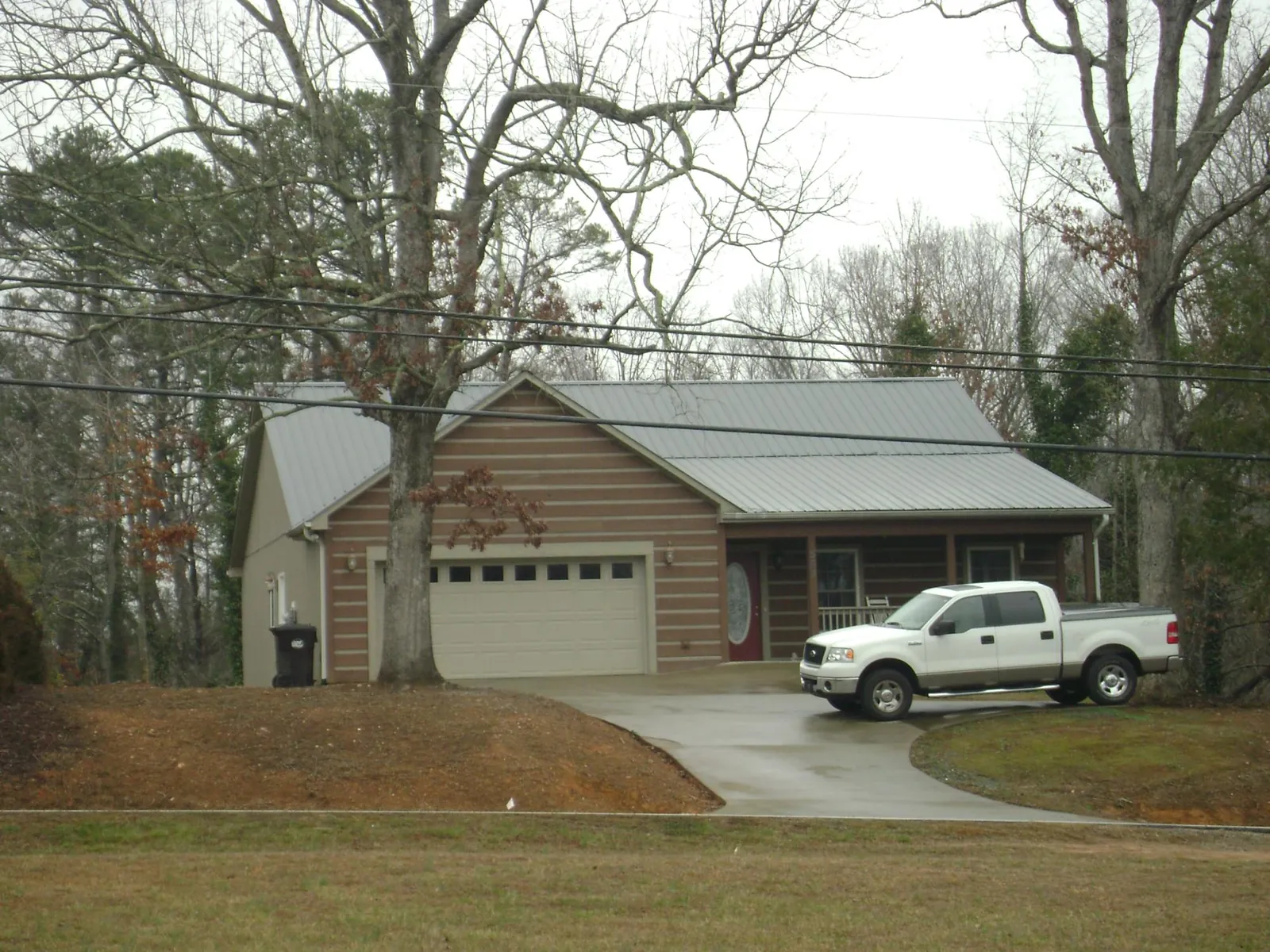 Gray metal roof on a log sided house with an attached two car garage in Sevierville